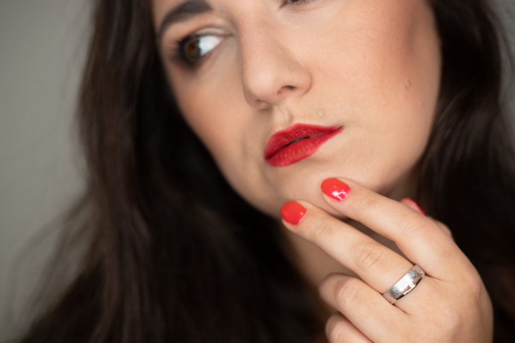 Schöne Frau mit tollen Make Up und roten Lippen. Schöner Ring im Mittelpunkt.